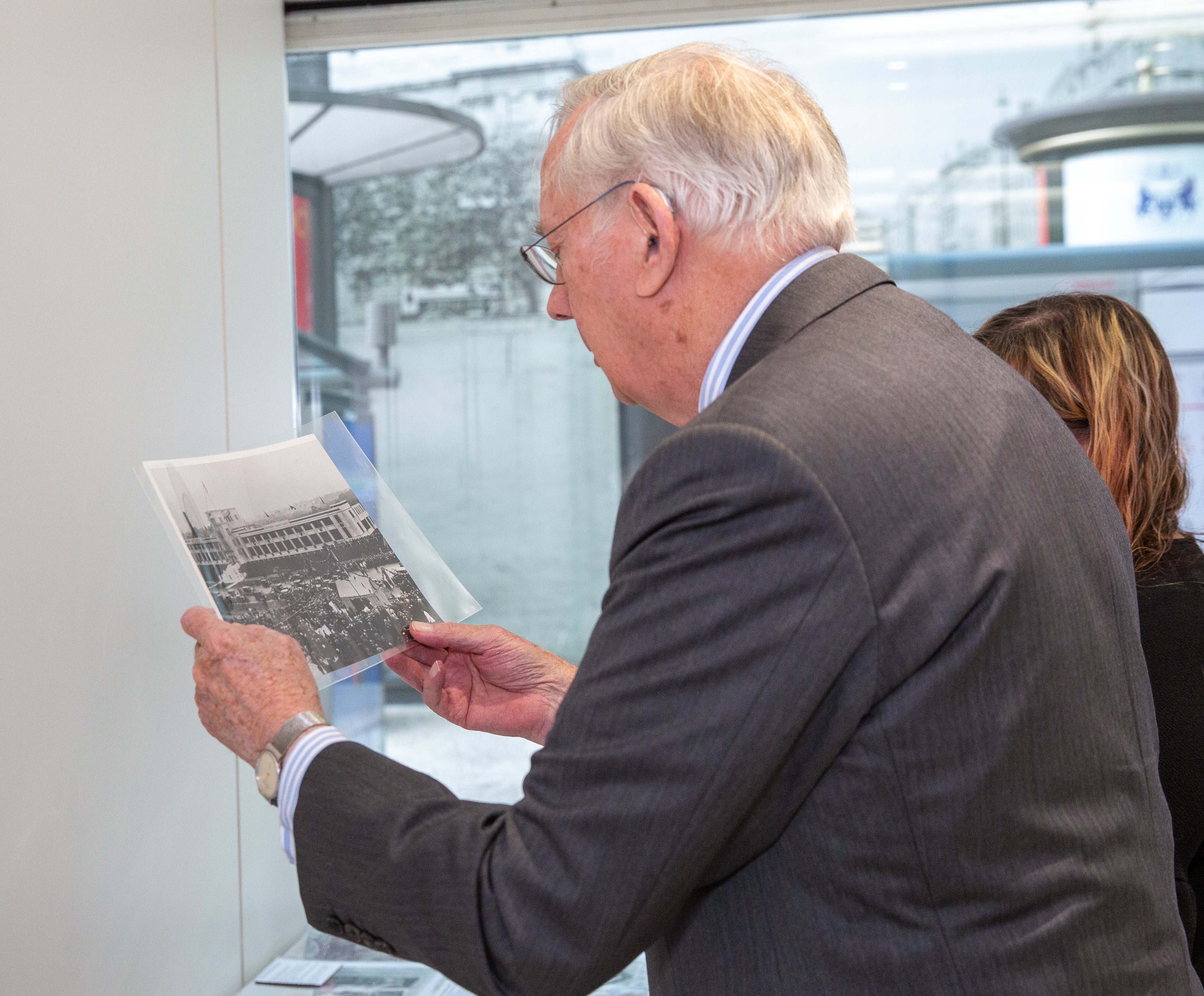 The Duke of Gloucester looks at a black and white photograph
