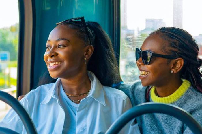 Two children on public bus smiling and looking out of window