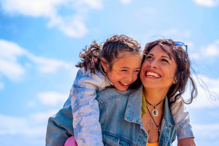 Woman with child on back having fun outdoors