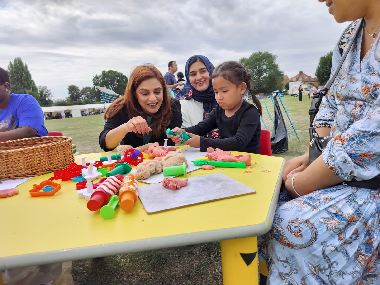 Cllr Chaudhary with parents and a child taking part in an art activity