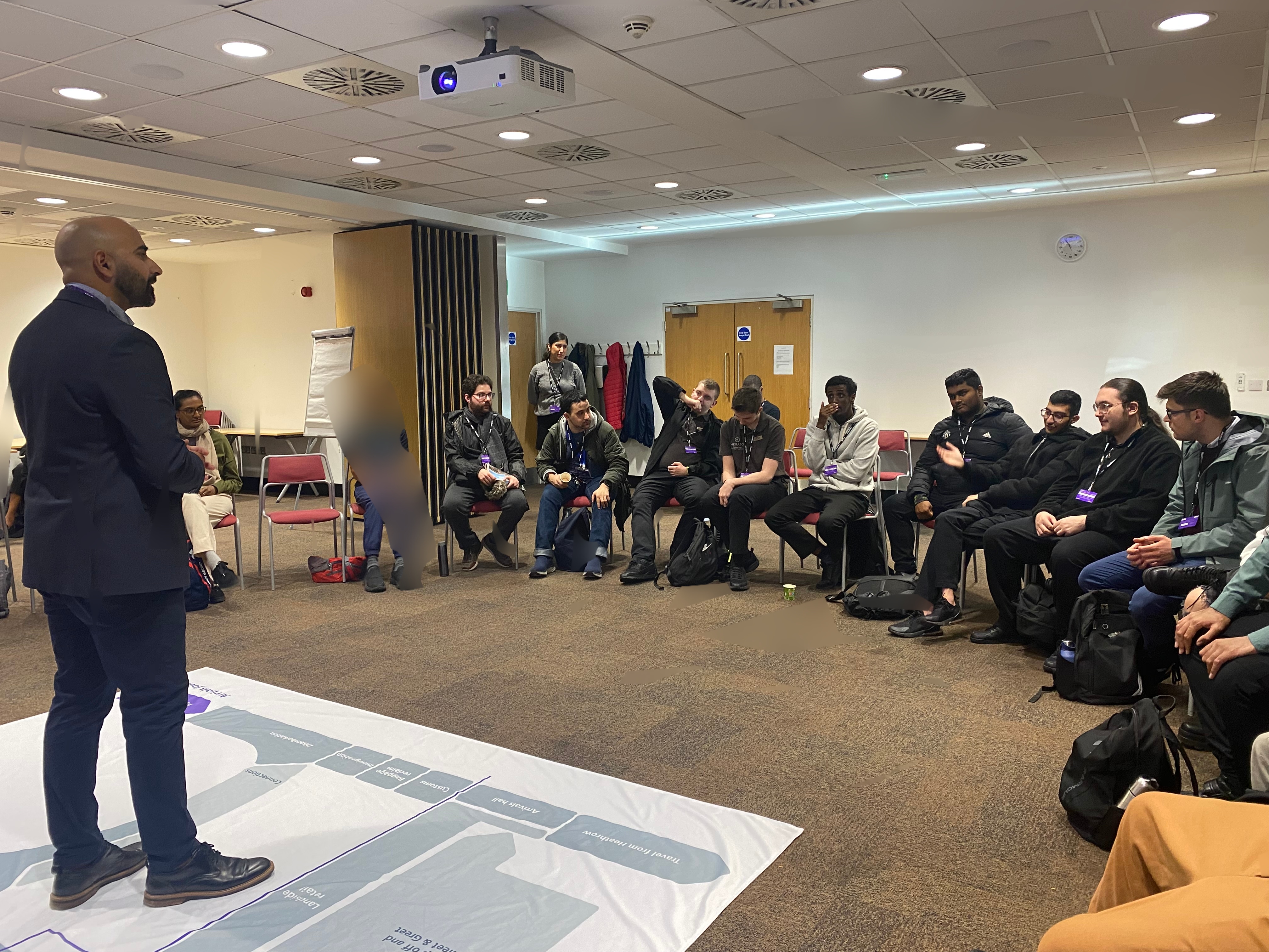 young people are sitting in a half-circle, listening to a talk
