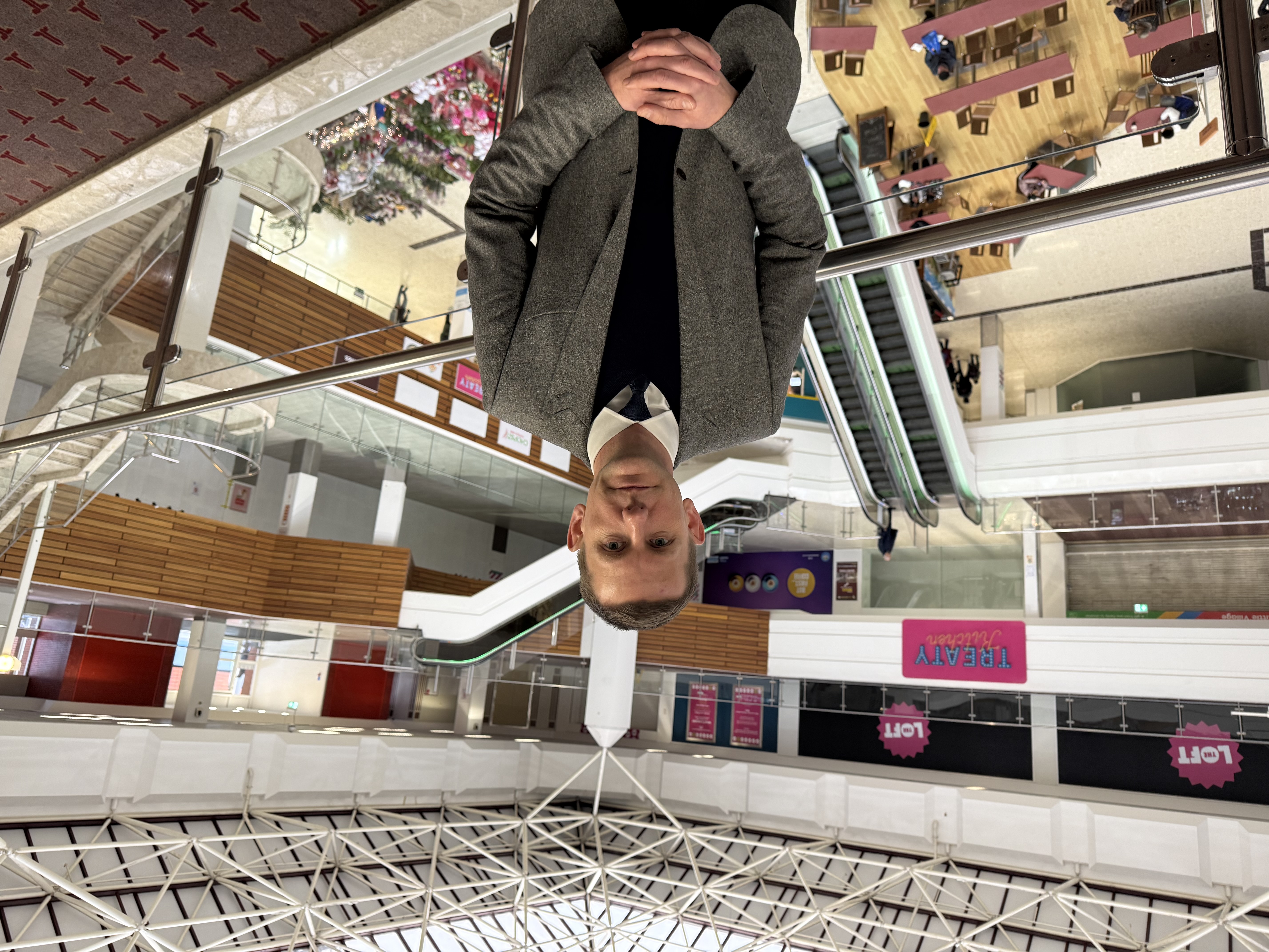 Cllr Bruce standing on the first floor of the Treaty Centre with the escalators behind