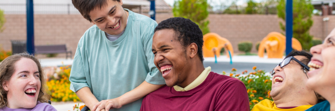 Young people with SEND laughing together in social setting.