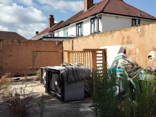 A back garden filled with dumped furniture