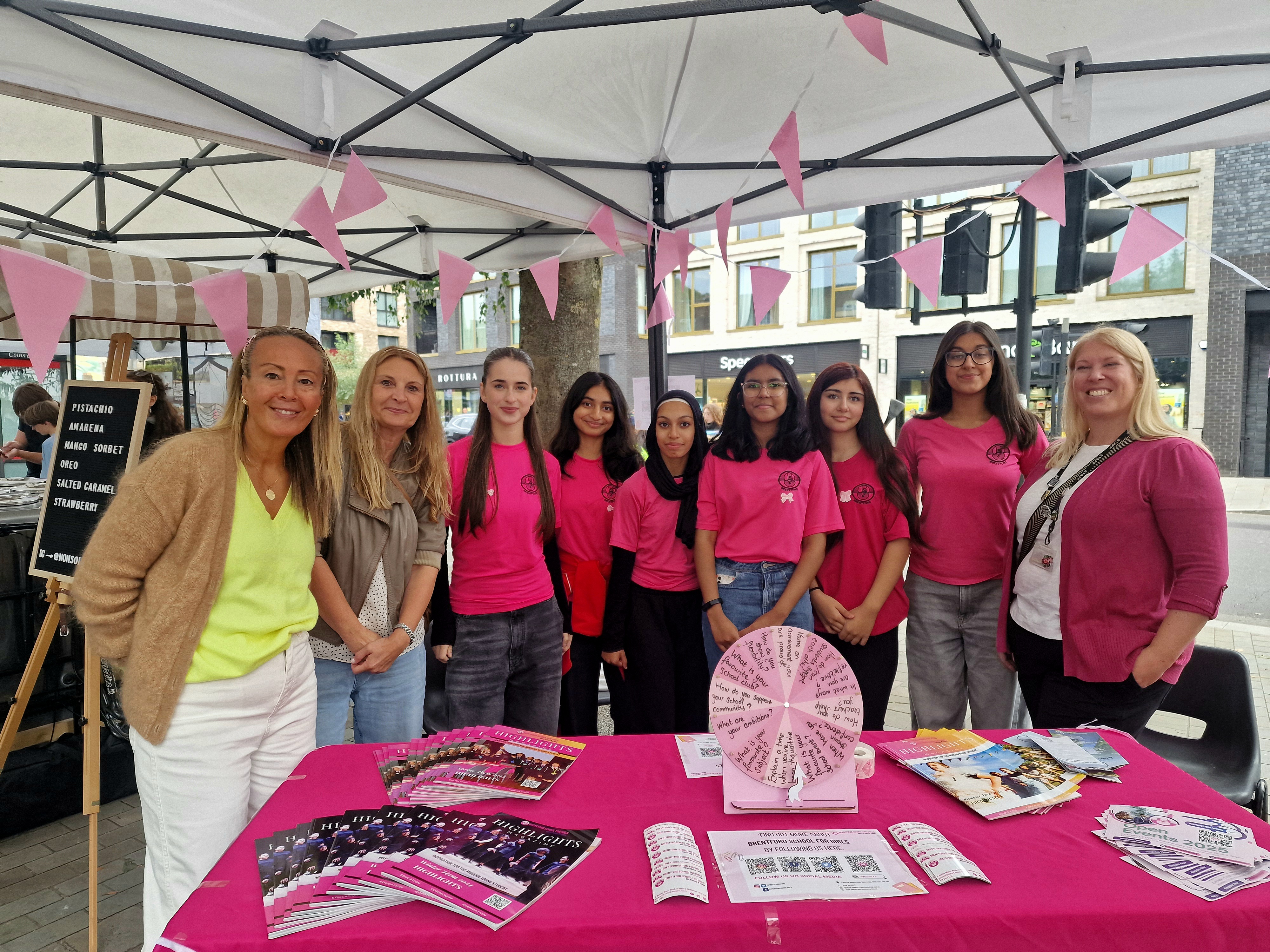 Some of the team dressed in pink behind a table at Brentford Community Day