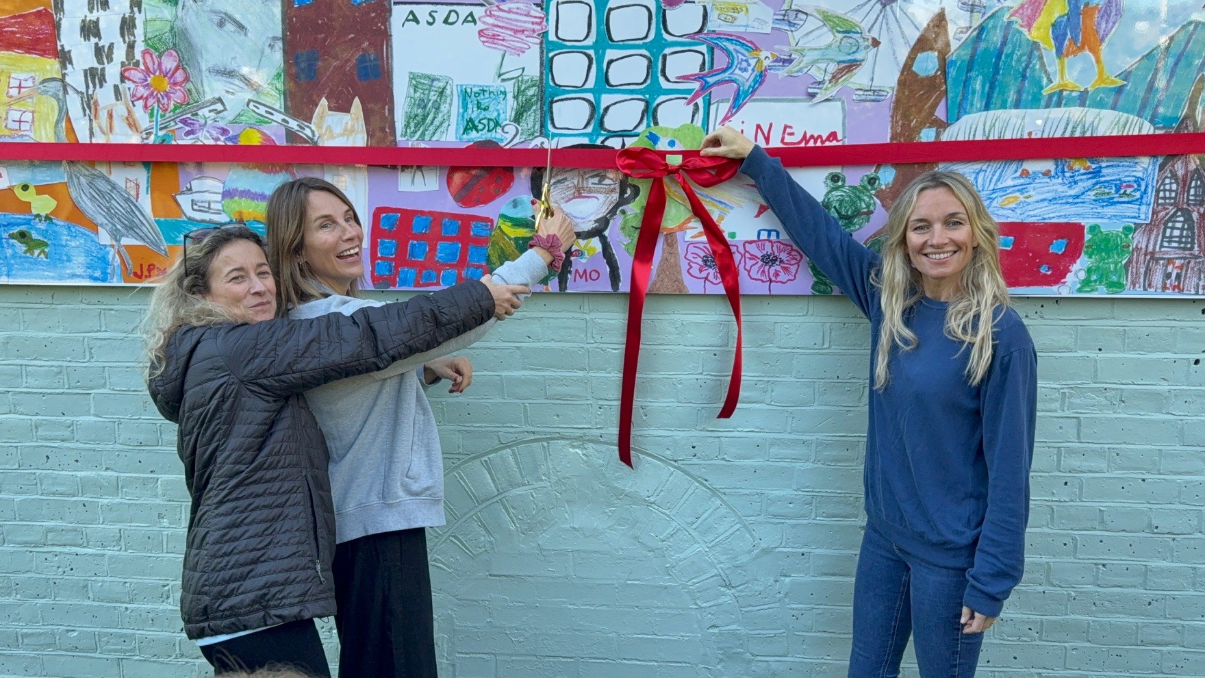 Timegivers' founder Kate Deighton with artists Leah Wood and Jemma Powell prepare to cut the ribbon