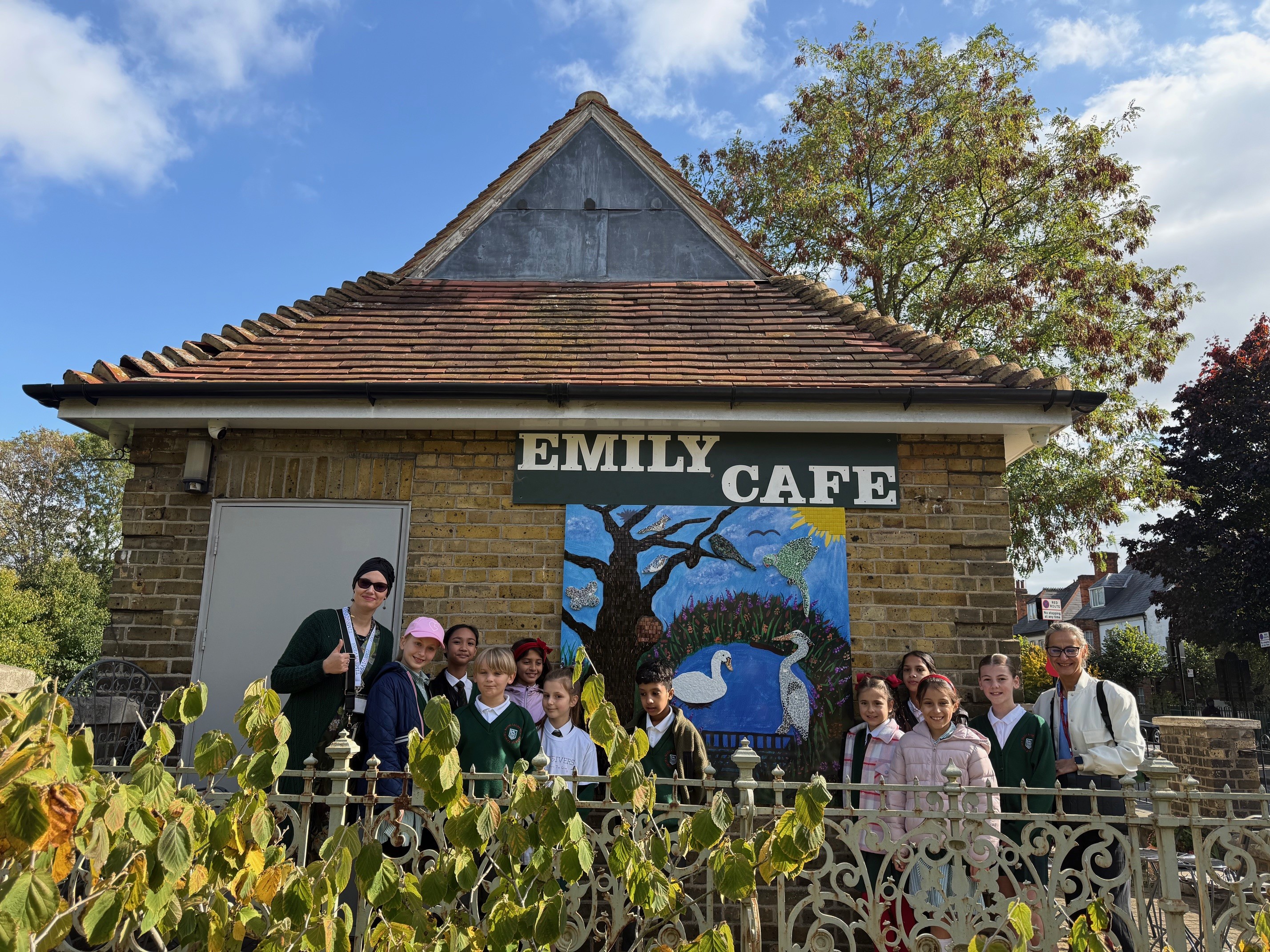 Local artist and school children in front of the mural on the side of Emily's Cafe