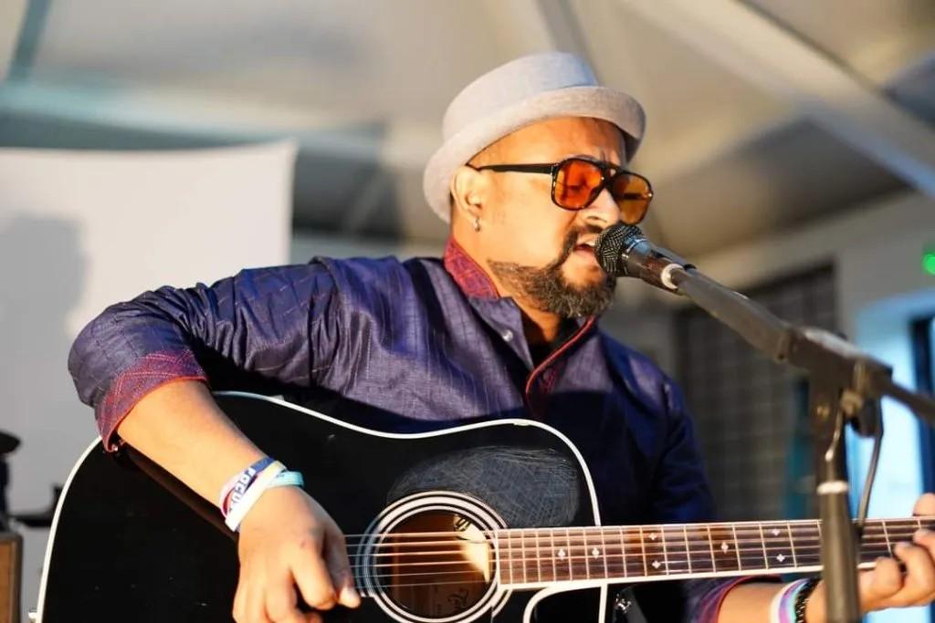 Artist known as Compound Radius playing guitar and singing.